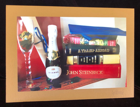 Graduation Still Life Scene with champagne bottle, champagne glass, stack of books, mortarboard., 