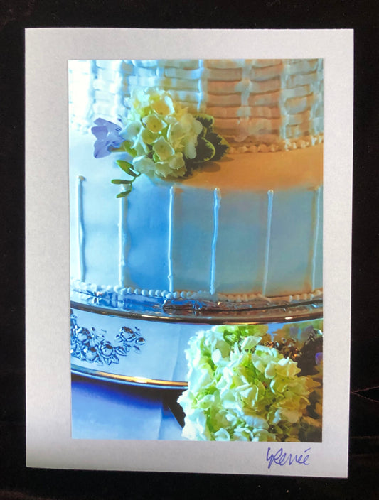 Closeup of wedding cake decorated with white hydrangeas.